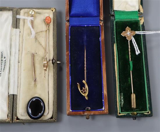 A 15ct gold wishbone stickpin, a diamond gypsy-set example and three other stickpins.